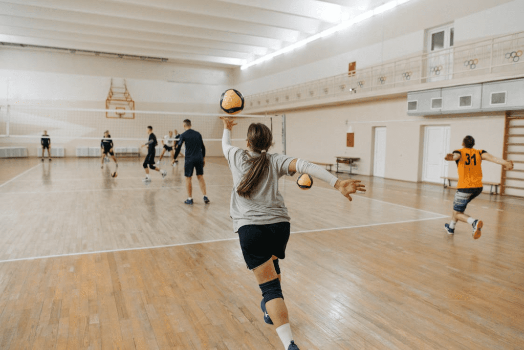 A person serving a volleyball.
